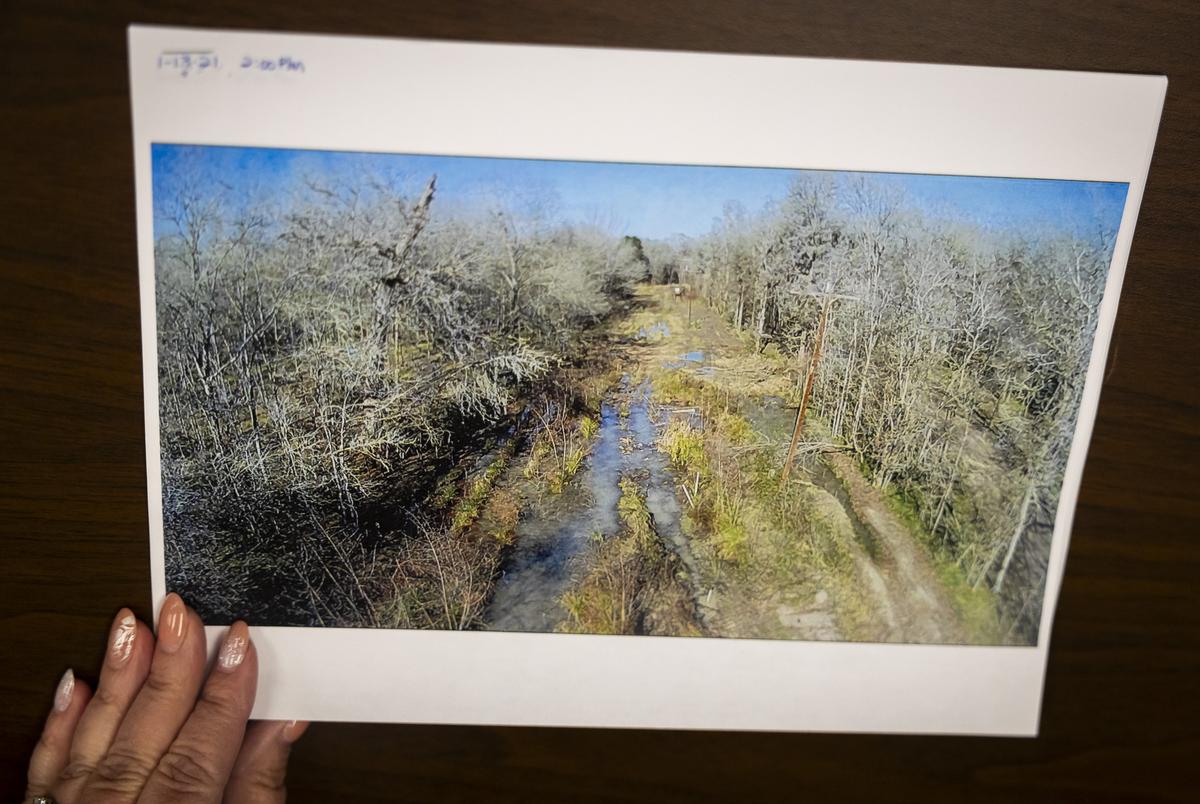 Kim Click, general manager of the Lake Livingston Water Supply, flips through photos of the flooding around the Trinity River at the water supply office on June 27, 2023.                                                                                                                          